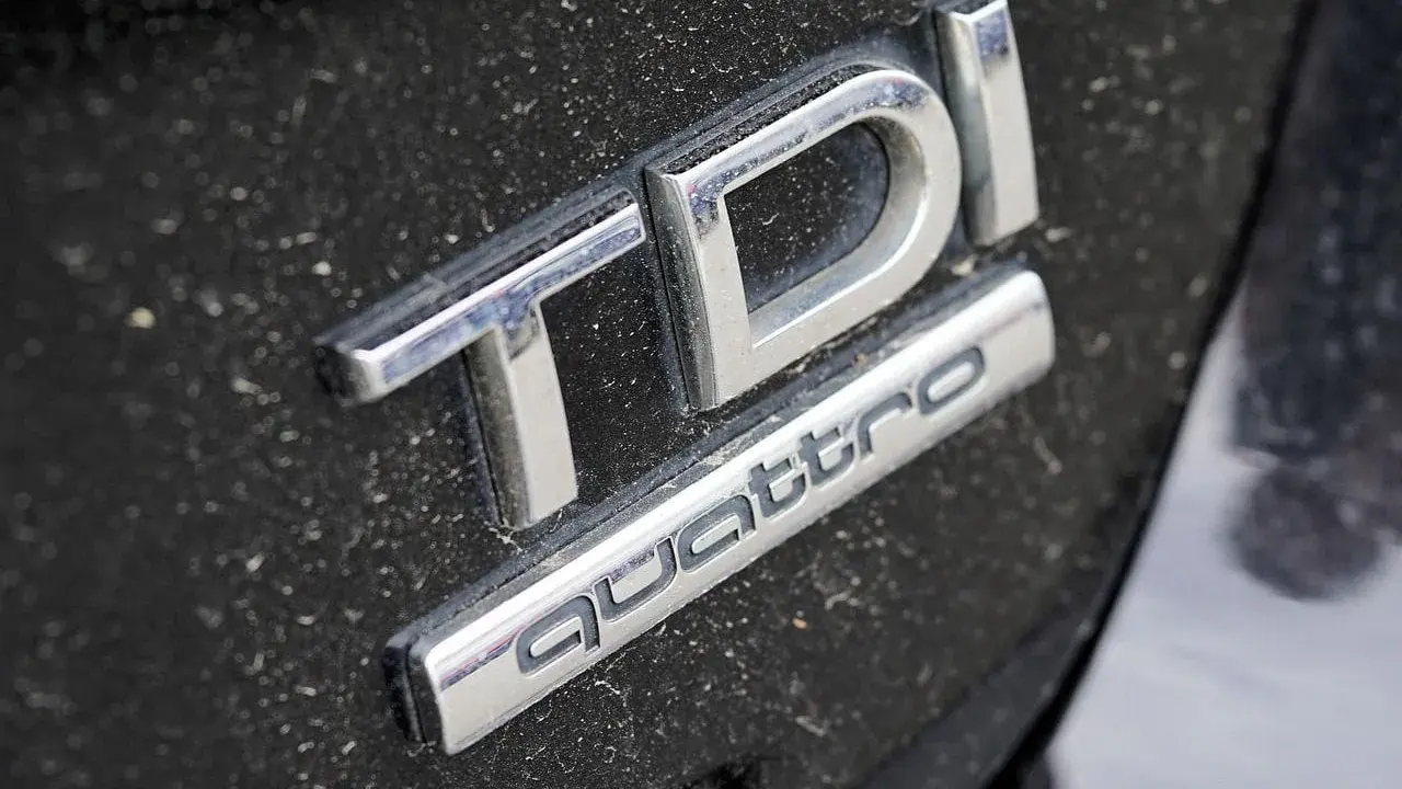Emblemat TDI Quattro na zakurzonej czarnej karoserii. Zastanawiasz się, 2.0 tdi ile oleju potrzeba?