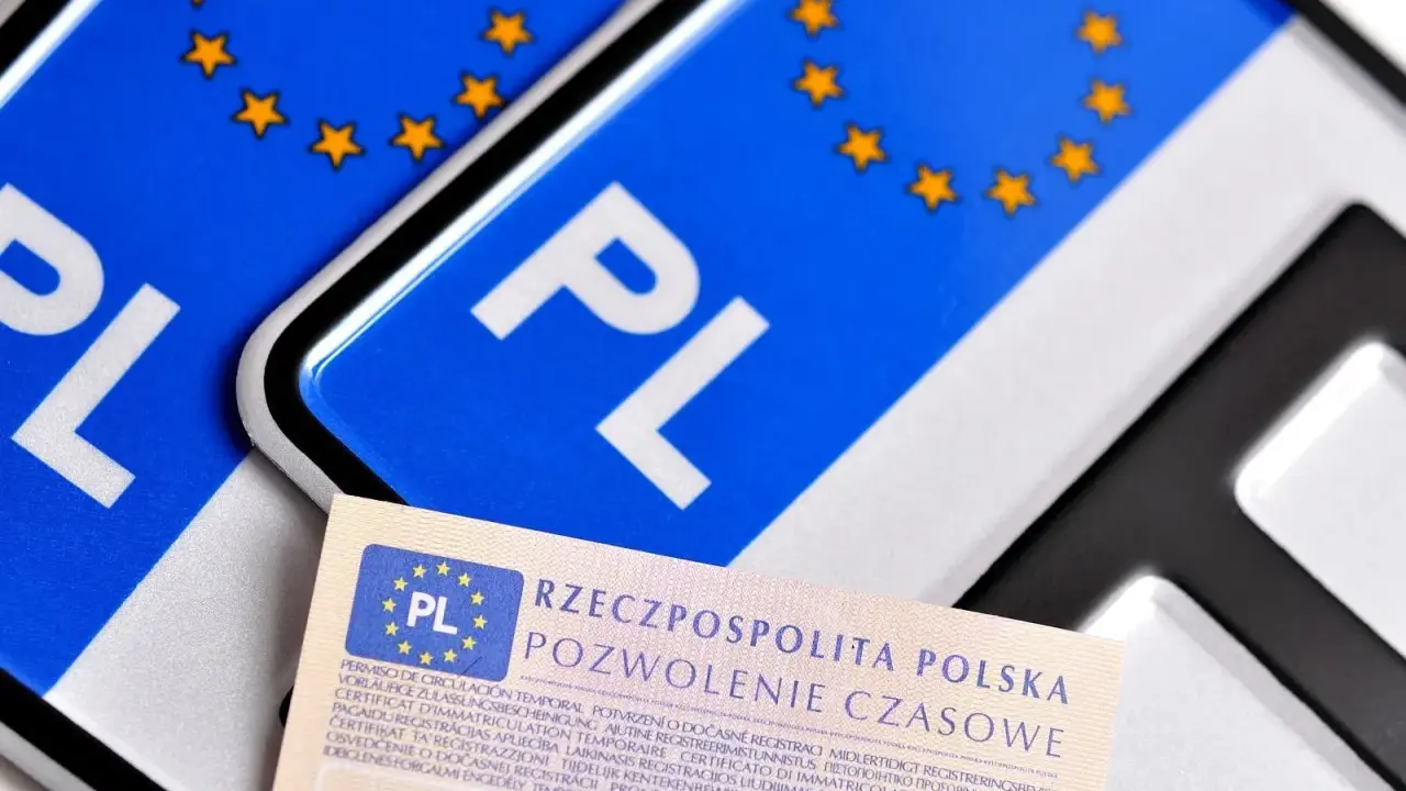 Pozwolenie czasowe pojazdu, dokument z symbolem PL i gwiazdkami UE, leży obok tablic rejestracyjnych.