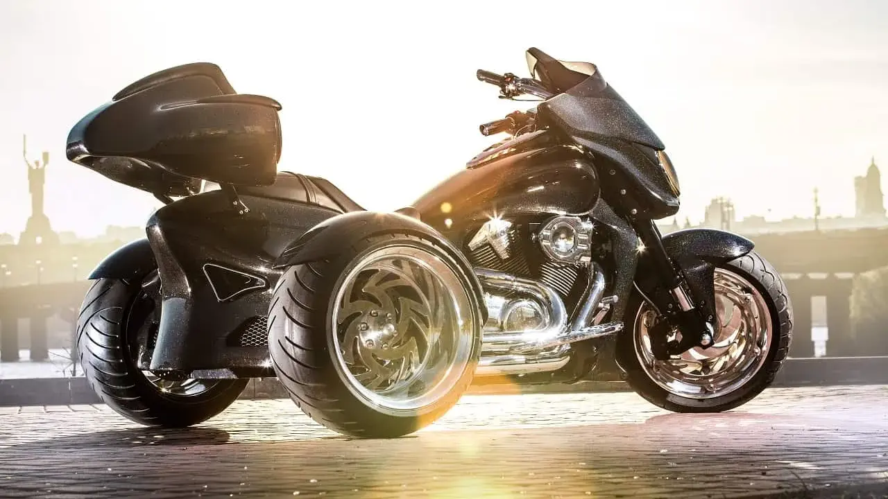 Czarny, lśniący motocykl trójkołowy na kat B. z chromowanymi felgami, gotowy na podbój miasta.