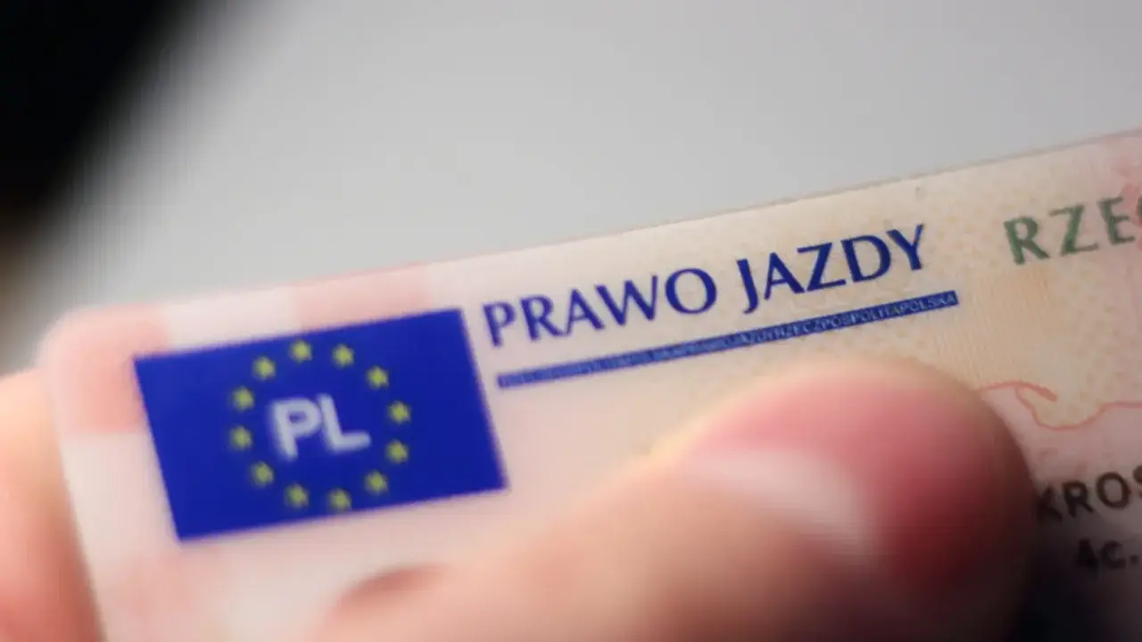 Zbliżenie na polskie prawo jazdy. Widoczny fragment karty z napisem "PRAWO JAZDY" i flagą UE z oznaczeniem "PL".