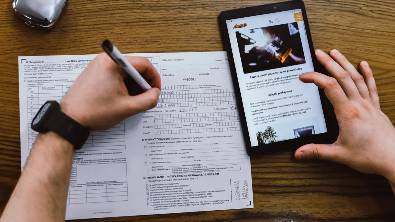 Wniosek o prawo jazdy, kurs na prawo jazdy online. Dokumenty i tablet z informacjami o kursach.