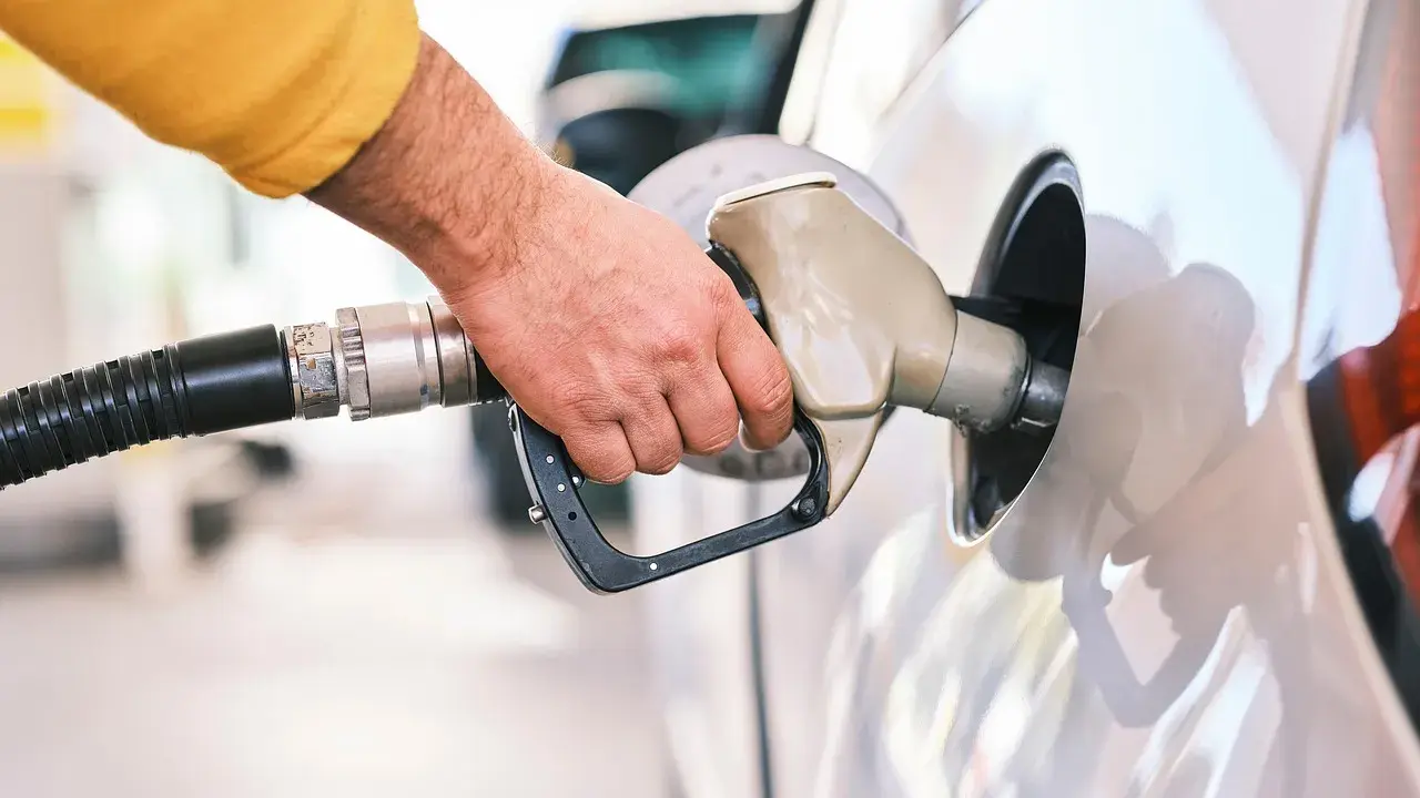 Dłoń tankuje samochód. Czy to tsi silnik benzyna czy diesel?
