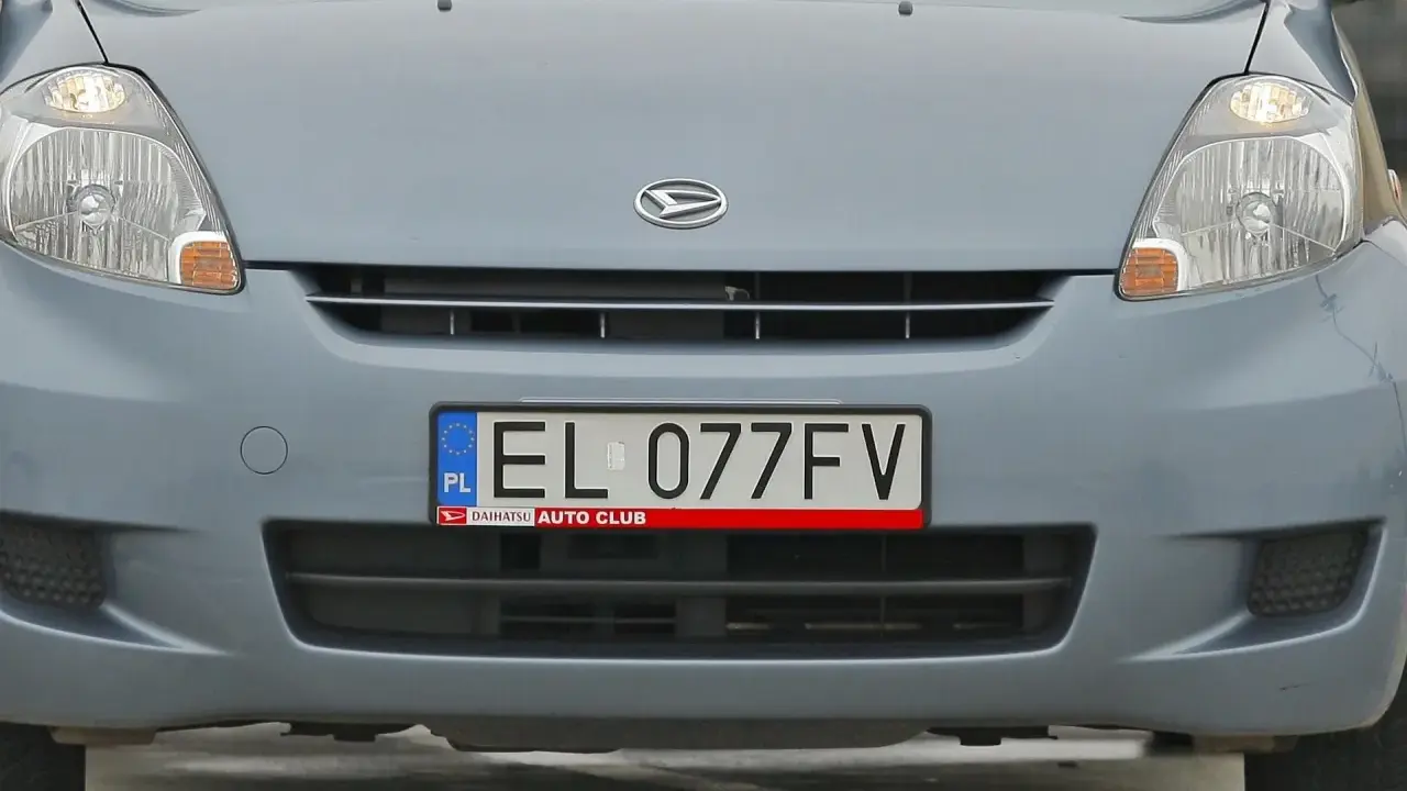 Szara atrapa samochodu z widocznym logo Daihatsu i polską tablicą rejestracyjną EL 077FV.