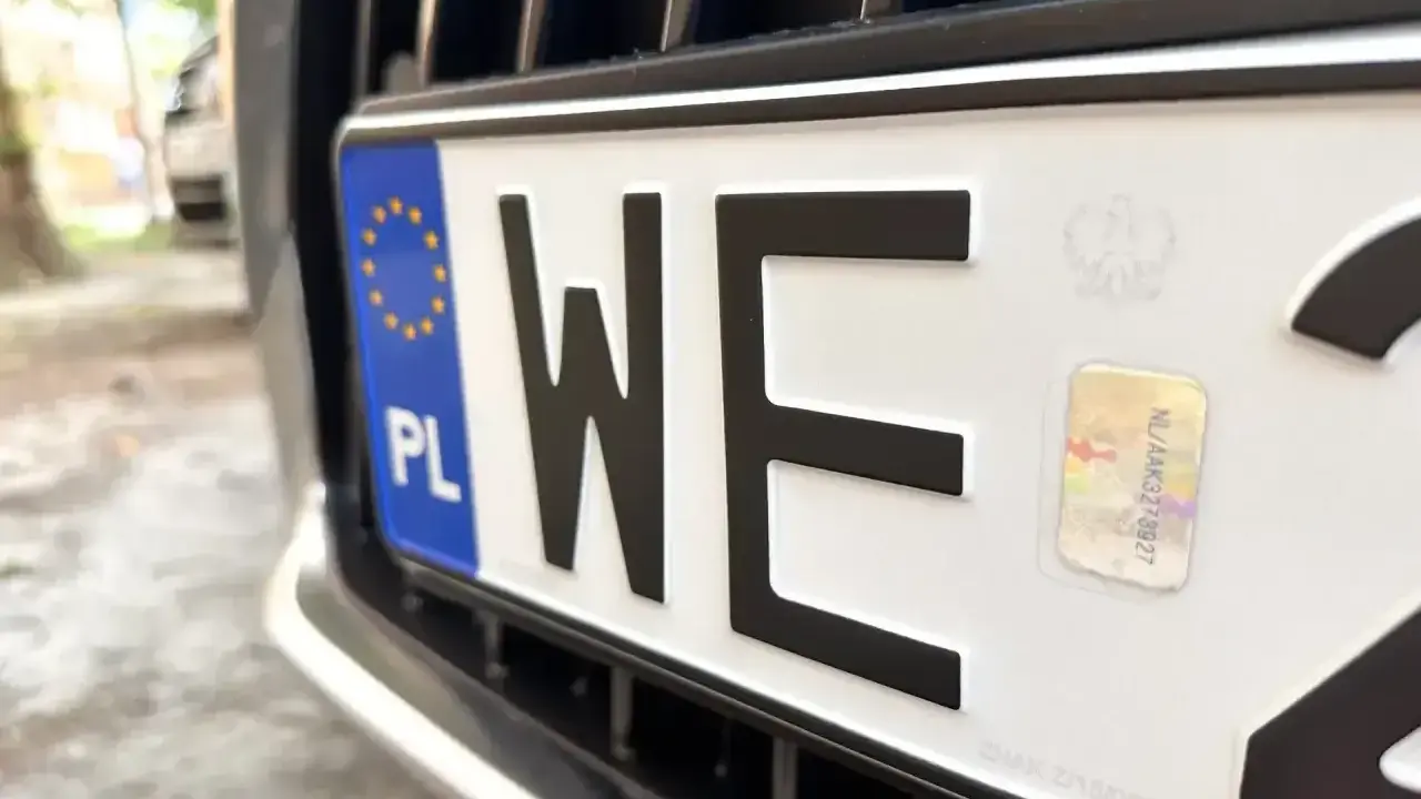 Zbliżenie na polską tablicę rejestracyjną z literami "WE". Ciekawi Cię, ile się czeka na tablice rejestracyjne?