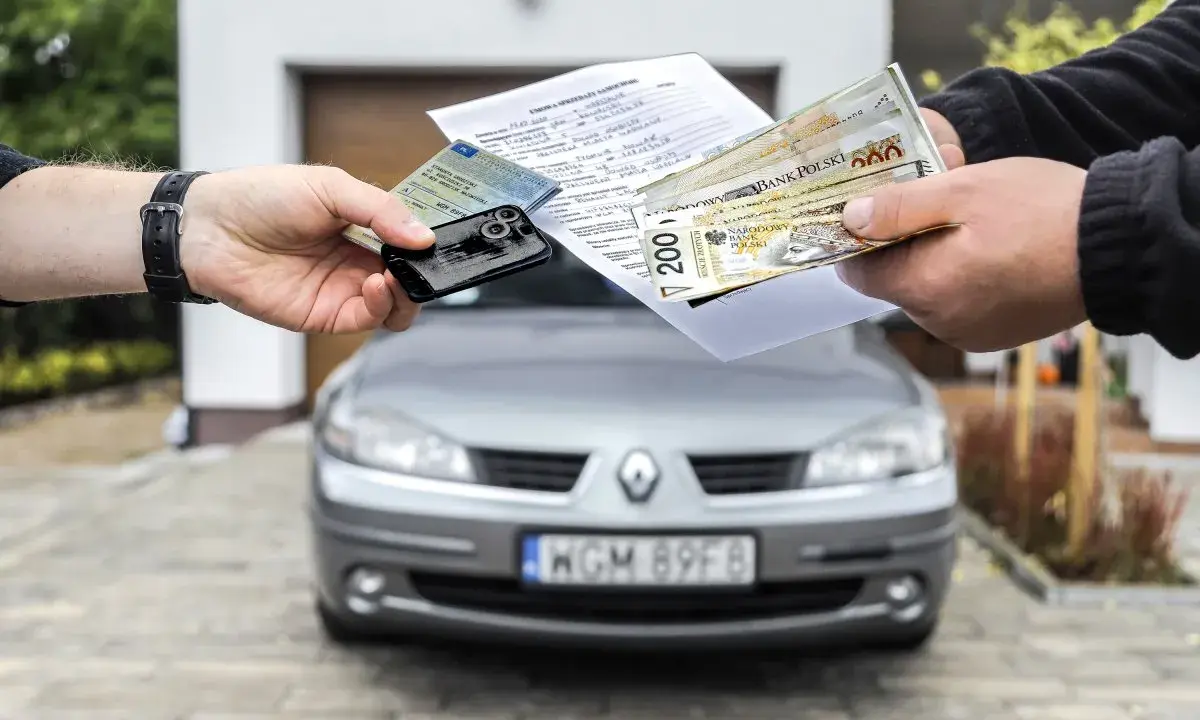 Transakcja kupna auta na dowód osobisty: dokumenty, kluczyki i pieniądze w rękach.