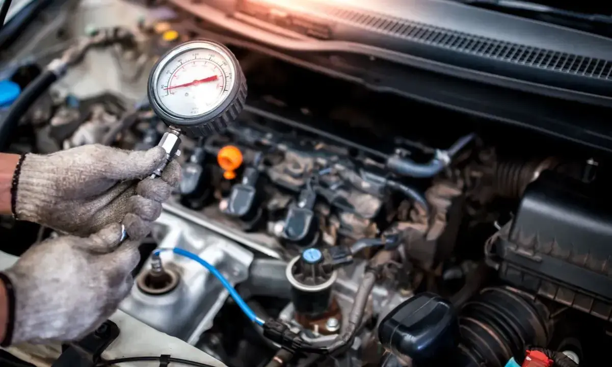 Mechanik sprawdza jakie minimalne ciśnienie sprężania diesel za pomocą manometru.