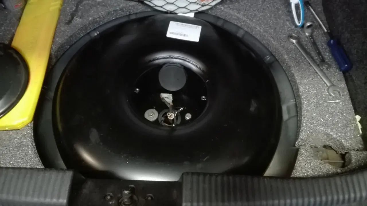 Przygotowania do wymiany butli LPG samemu. Widać narzędzia i pustą butlę w bagażniku.