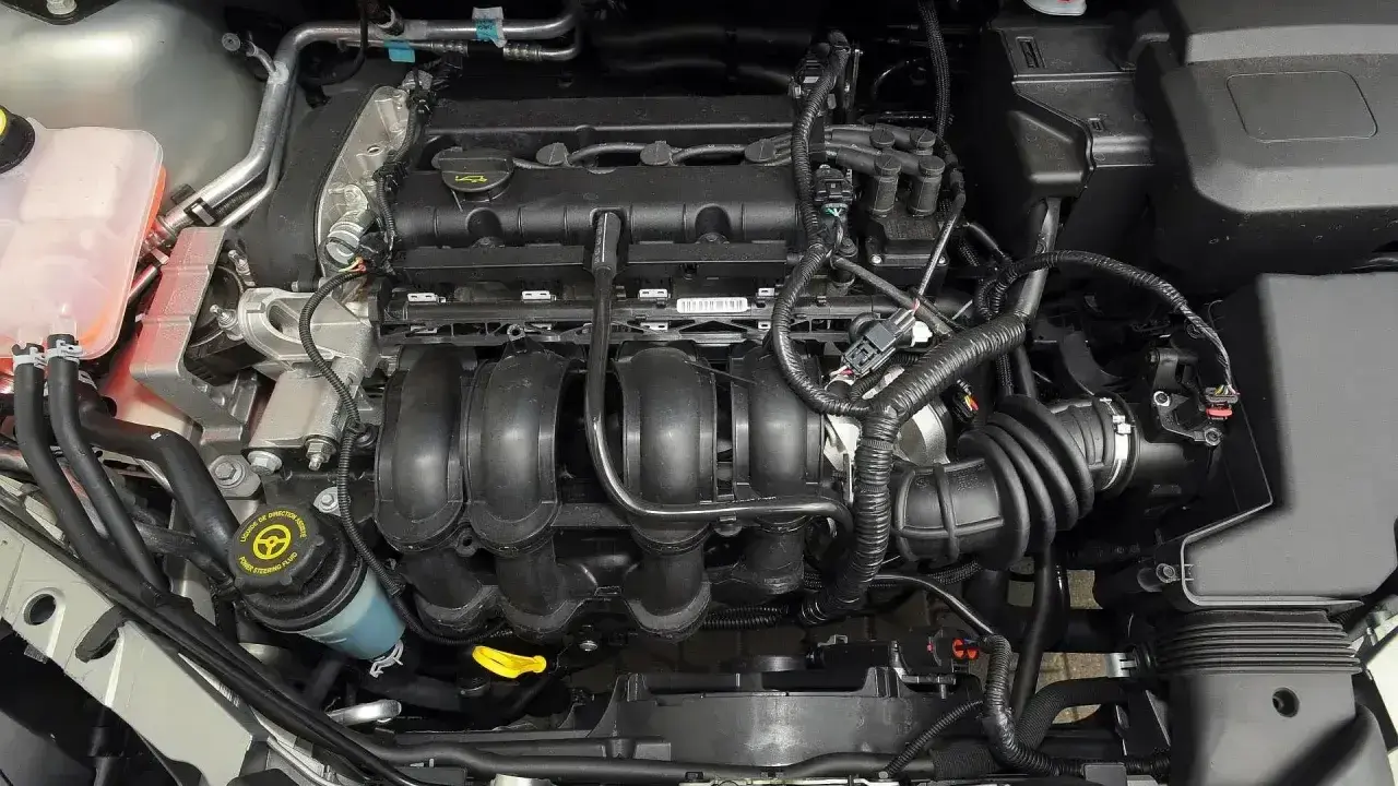 Silnik Ford Focus MK2, widok z góry. Widać kolektor dolotowy, przewody i zbiornik płynu wspomagania.