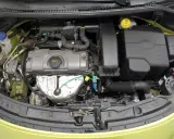 Silnik w Peugeot 207, z widocznymi elementami układu dolotowego i chłodzenia.