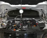 Mechanik sprawdza ciśnienie sprężania diesel w silniku samochodu za pomocą manometru.