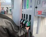Mężczyzna tankuje paliwo verva na stacji. Wybiera dystrybutor z zieloną końcówką.