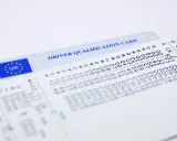 Karta kwalifikacji kierowcy z oznaczeniem UK i UE, obok wydruk z tachografu.