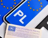 Pozwolenie czasowe pojazdu, dokument z symbolem PL i gwiazdkami UE, leży obok tablic rejestracyjnych.
