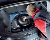 Mechanik sprawdza butlę LPG w bagażniku. Dowiedz się, jaki jest koszt wymiany butli LPG i kiedy jest ona konieczna.