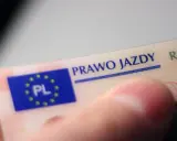 Zbliżenie na polskie prawo jazdy. Widoczny fragment karty z napisem "PRAWO JAZDY" i flagą UE z oznaczeniem "PL".