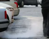 Para samochodu z białym dymem z rury wydechowej. Dym jest biały, jakby był to kolor benzyny, która nie spaliła się całkowicie.