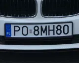 Biała tablica rejestracyjna z kodem PO 8MH80, z niebieskim paskiem UE i literami PL.