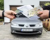 Transakcja kupna auta na dowód osobisty: dokumenty, kluczyki i pieniądze w rękach.