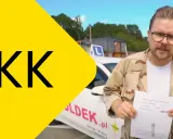 Jak wyrobić PKK? Mężczyzna w okularach trzyma dokument przed samochodem z literą L.