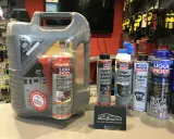 Duży kanister oleju silnikowego i kilka mniejszych preparatów do pielęgnacji samochodu, w tym dodatki do paliwa i płyny. Wszystkie oleje i preparaty to produkty marki Liqui Moly.
