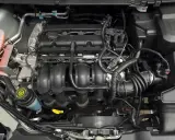 Silnik Ford Focus MK2, widok z góry. Widać kolektor dolotowy, przewody i zbiornik płynu wspomagania.