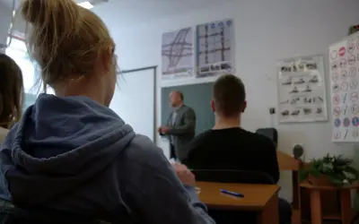 Nauka do egzaminu na prawo jazdy 3 miesiące przed 18. Uczniowie słuchają wykładu o przepisach drogowych.