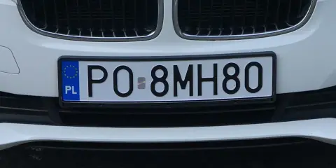 Biały samochód z tablicą rejestracyjną PO-8MH80.