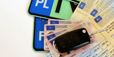 Kluczyki do auta, kilka praw jazdy i dowody rejestracyjne – wszystko gotowe na wniosek o wydanie prawa jazdy po zdanym egzaminie.