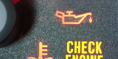 Czerwona kontrolka wymiany oleju świeci się obok ikony termometru i napisu "CHECK ENGINE". Czas na serwis!