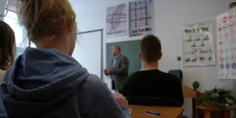 Nauka do egzaminu na prawo jazdy 3 miesiące przed 18. Uczniowie słuchają wykładu o przepisach drogowych.