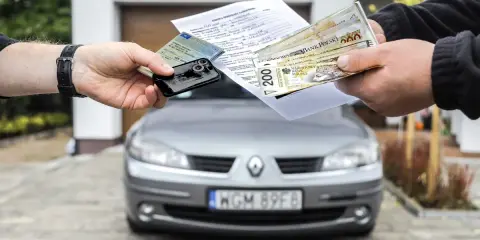 Transakcja kupna auta na dowód osobisty: dokumenty, kluczyki i pieniądze w rękach.