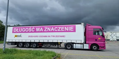 Różowa ciężarówka z napisem "Długość ma znaczenie. Zrób kurs i egzamin na tym zestawie!" zachęca do zdania egzaminu kwalifikacji zawodowej kierowcy.