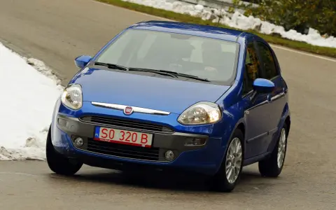 Niebieski Fiat z polskimi tymczasowymi tablicami rejestracyjnymi SO 320 B jedzie po krętej drodze, po bokach śnieg.