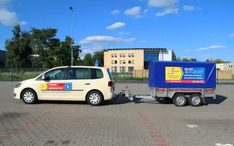 Samochód szkoleniowy z przyczepą, gotowy do nauki jazdy. Kod 96 prawo jazdy to specjalność tej szkoły.