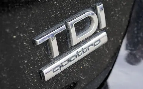 Emblemat TDI Quattro na zakurzonej czarnej karoserii. Zastanawiasz się, 2.0 tdi ile oleju potrzeba?