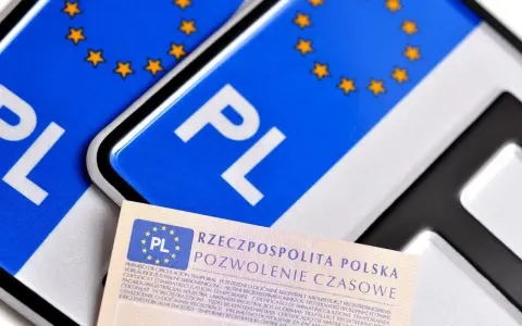 Pozwolenie czasowe pojazdu, dokument z symbolem PL i gwiazdkami UE, leży obok tablic rejestracyjnych.