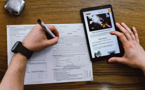 Wniosek o prawo jazdy, kurs na prawo jazdy online. Dokumenty i tablet z informacjami o kursach.