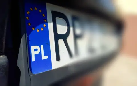 Zbliżenie na polską tablicę rejestracyjną z symbolem Unii Europejskiej. Litery "PL" i fragment numeru rejestracyjnego są wyraźne.