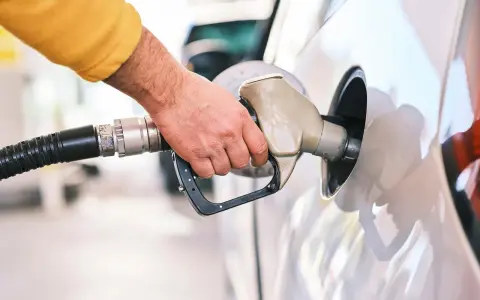 Dłoń tankuje samochód. Czy to tsi silnik benzyna czy diesel?