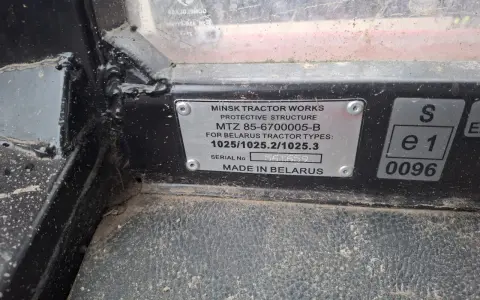 Tabliczka znamionowa z napisem "MINSK TRACTOR WORKS", zawierająca dane techniczne i numer seryjny traktora. Nazwa organu rejestrującego nie jest widoczna.