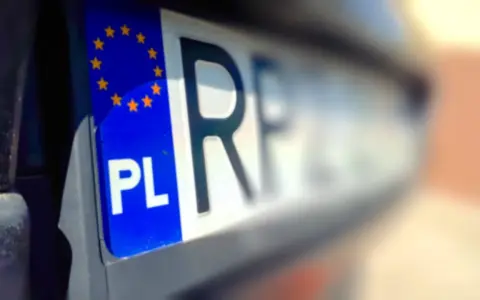 Zbliżenie na polską tablicę rejestracyjną z symbolem UE. Czy przy przerejestrowaniu samochodu trzeba oddać tablice?