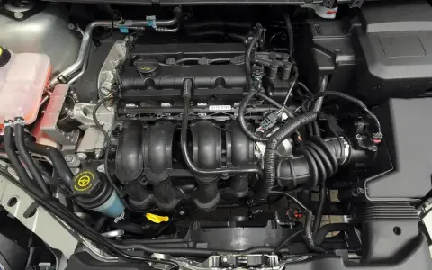 Silnik Ford Focus MK2, widok z góry. Widać kolektor dolotowy, przewody i zbiornik płynu wspomagania.