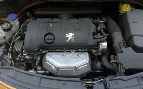 Silnik Peugeota 207. Jaki silnik wybrać? Widok na jednostkę napędową z logo lwa.