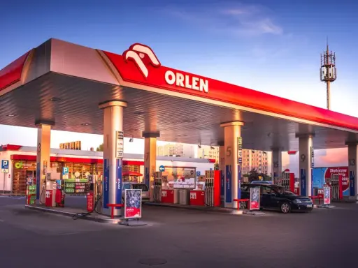 Stacja Orlen z dystrybutorami verva diesel i benzyny. W tle McDonald's i budynki mieszkalne.