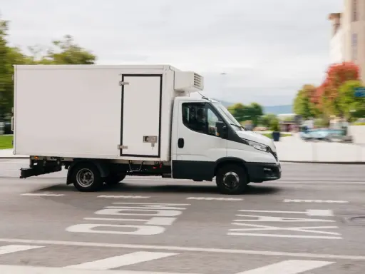 Biała chłodnia na podwoziu Iveco Daily, idealna do transportu towarów wymagających niskiej temperatury. Posiadanie prawa jazdy C1 pozwala na prowadzenie tego typu pojazdu.
