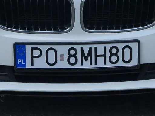 Biały samochód z tablicą rejestracyjną PO-8MH80.