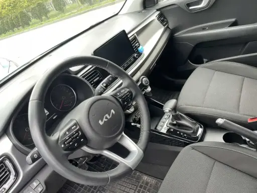 Wnętrze samochodu z automatyczną skrzynią biegów. Widoczna kierownica, deska rozdzielcza i dźwignia zmiany biegów. Idealne do zdobycia prawo jazdy na automat oznaczenie.
