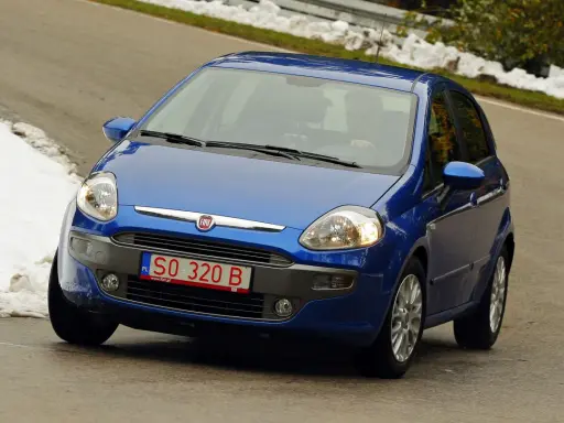 Niebieski Fiat z polskimi tymczasowymi tablicami rejestracyjnymi SO 320 B jedzie po krętej drodze, po bokach śnieg.