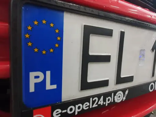 Zbliżenie na polską tablicę rejestracyjną z symbolem UE i literami "EL". To ważny element identyfikacyjny pojazdu, umożliwiający jego rejestrację.