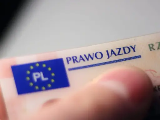 Zbliżenie na polskie prawo jazdy. Widoczny fragment karty z napisem "PRAWO JAZDY" i flagą UE z oznaczeniem "PL".